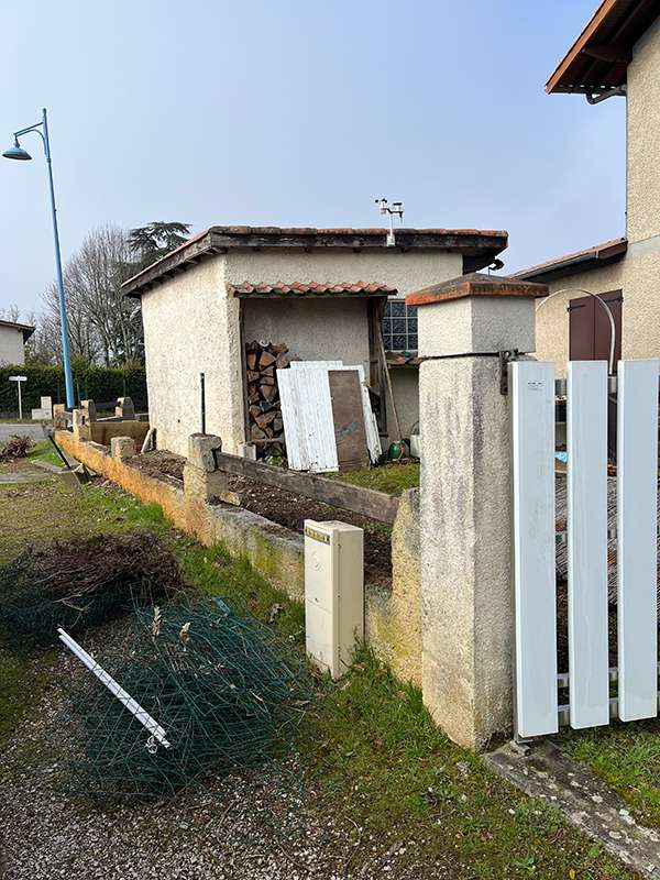 Vue détaillée du chantier à Pamiers, avec la pose d'une clôture et les fondations en place, montrant les matériaux et l'avancement des travaux.