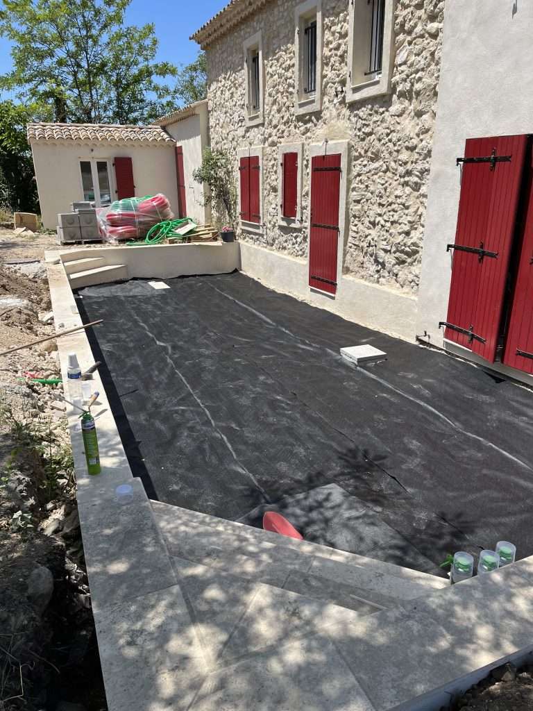 Terrasse en cours de rénovation à Roques-sur-Garonne, préparation du sol avec toile géotextile avant la pose de gravier par Occitanie Espaces Verts.